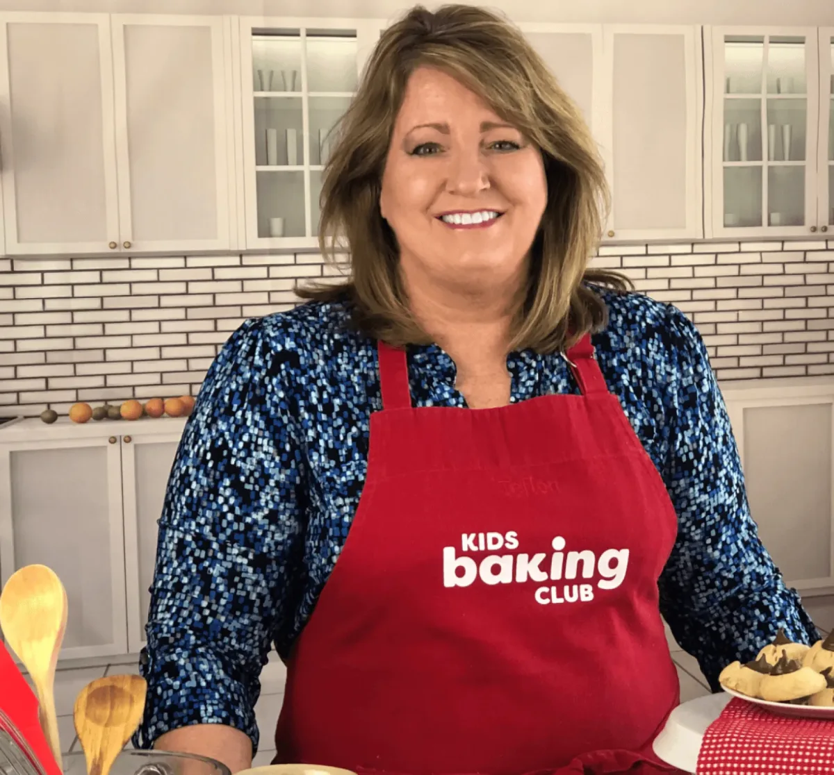 A Kids Baking Club host in a branded apron